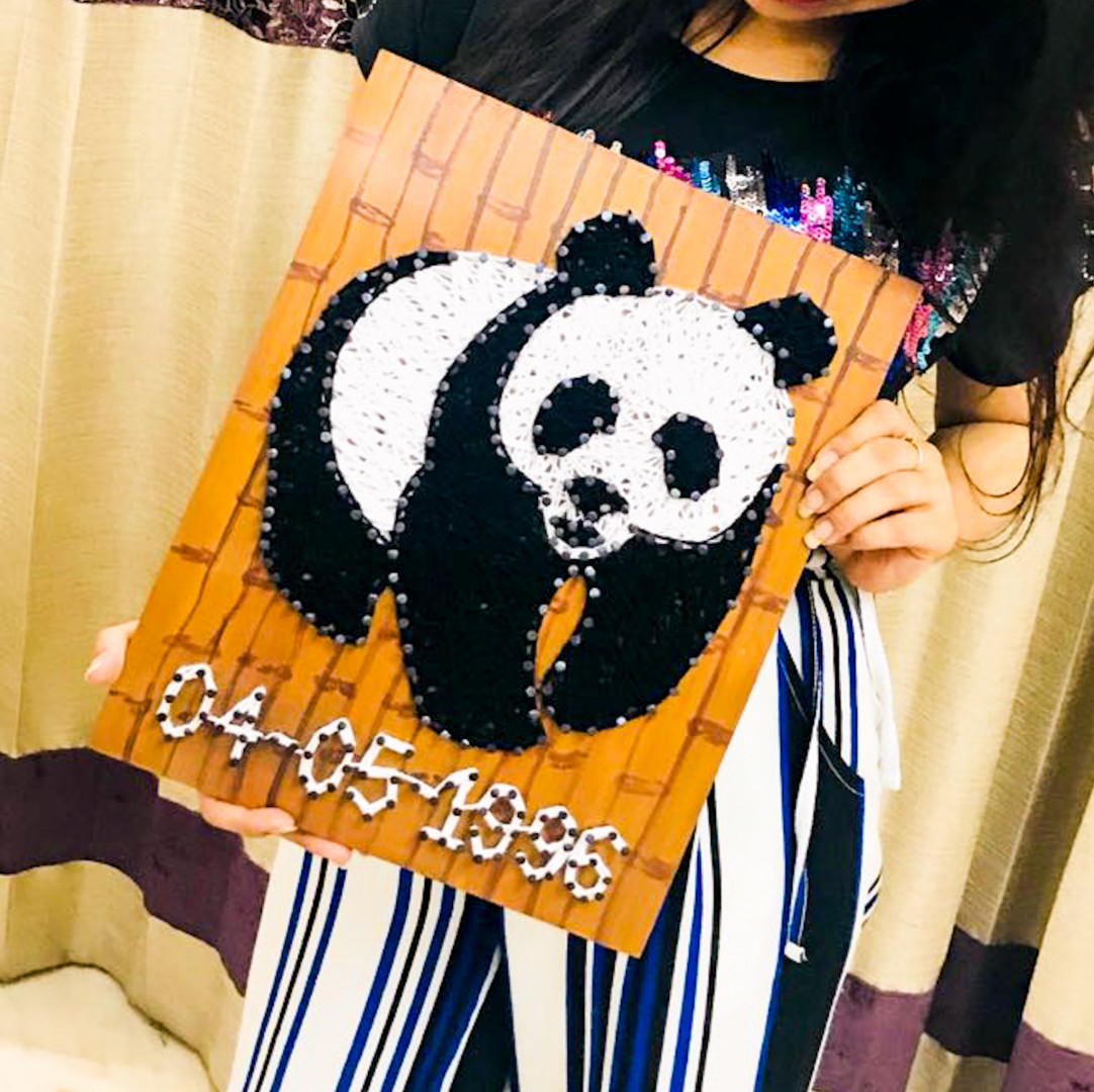 Panda themed string art on wooden panel