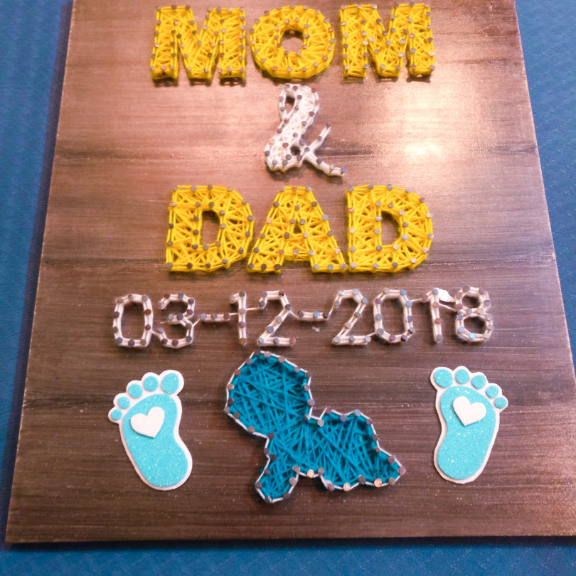 New born baby themed string art on wooden panel